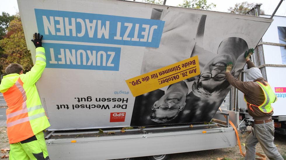 Arbeiter verladen ein Wahlplakat für den SPD-Spitzenkandidaten Thorsten Schäfer-Gümbel auf einen Anhänger. 