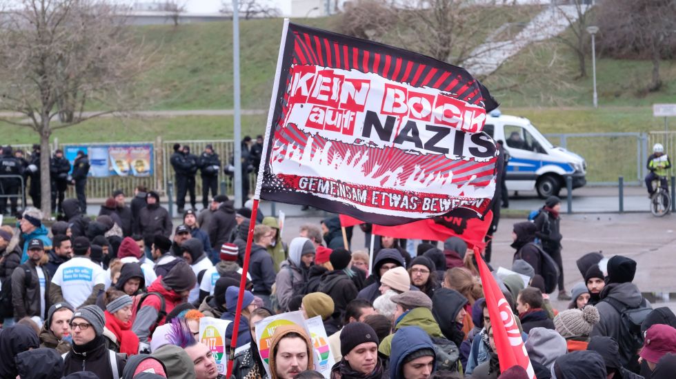 Teilnehmer einer Demonstration versammeln sich vor der Sachsen- Arena und halten ein Transparent "Kein Bock auf Nazis". Sie protestieren gegen den Bundesparteitag der AfD, der zeitgleich dort abgehalten wird