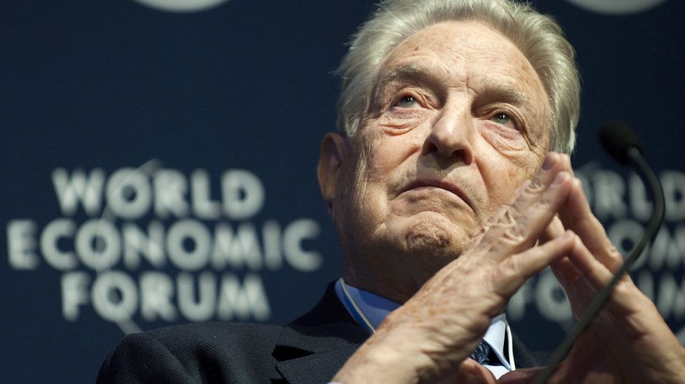George Soros am Mikrofon mit gefalteten Händen während des World Economic Forum