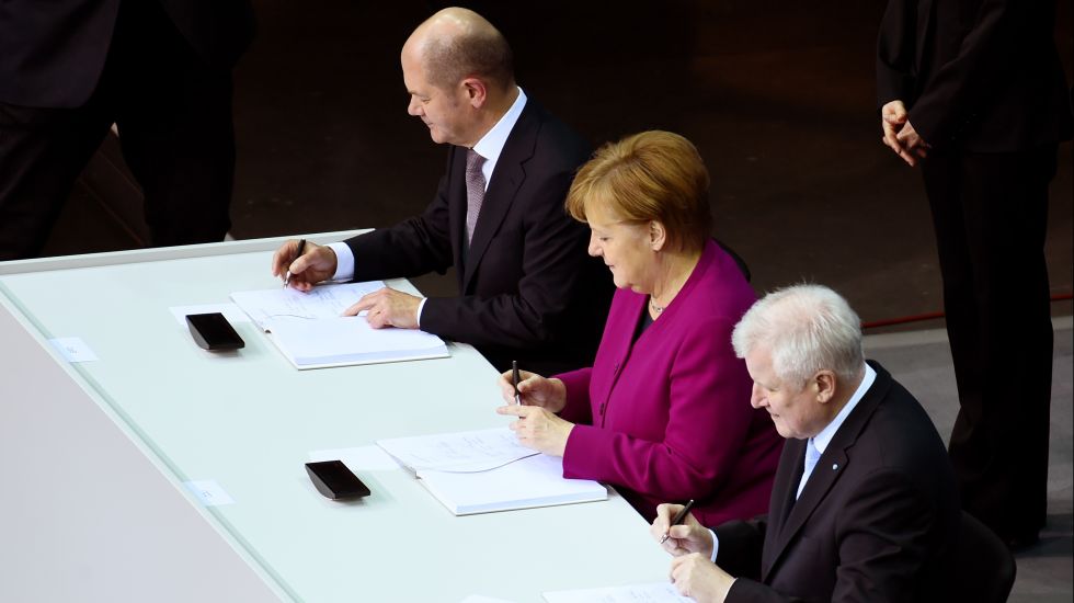 Bundeskanzlerin Angela Merkel (CDU), der CSU-Vorsitzende Horst Seehofer (r) und der kommissarische SPD-Vorsitzende Olaf Scholz unterzeichnen im Paul-Löbe-Haus den Koalitionsvertrag. 