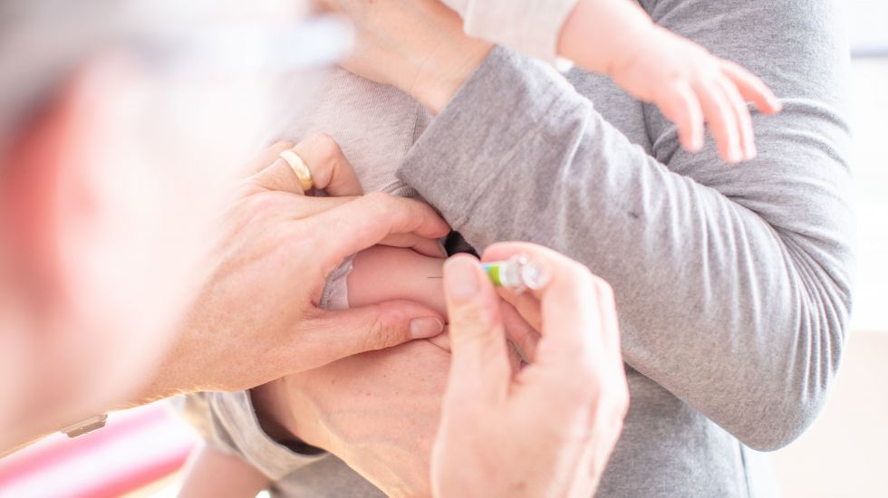25.02.2019, Nordrhein-Westfalen, Bielefeld: Ein Säugling bekommt bei einer Vorsorgeuntersuchung in der Praxis von einem Kinderarzt eine Impfung mit einer Spritze. 