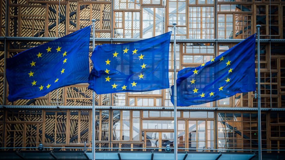 Drei Flaggen der europäischen Union wehen vor einem Gebäude 