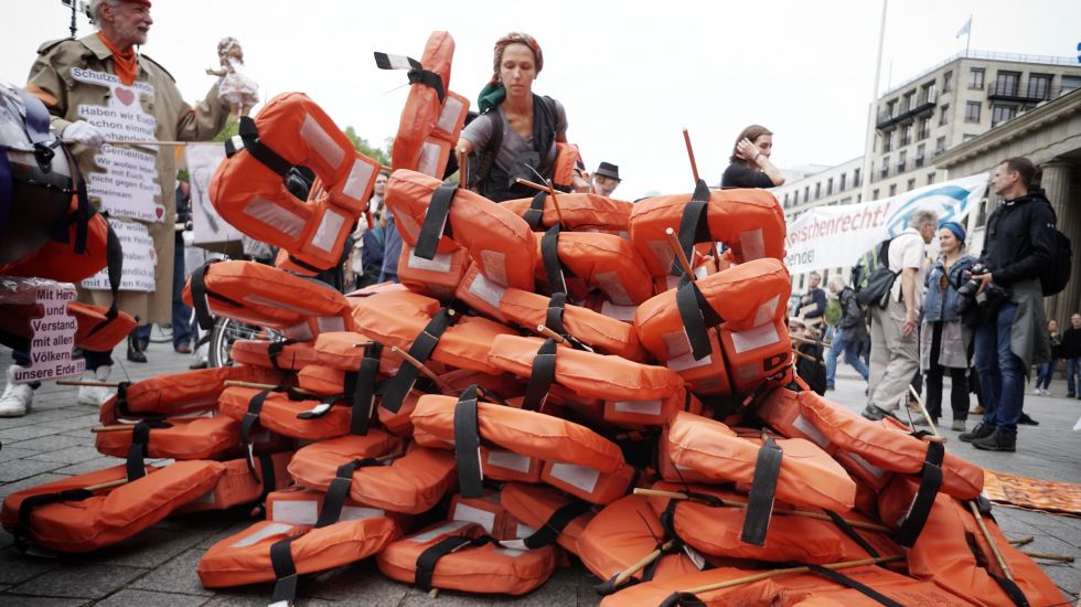 Teilnehmer demonstrieren vor dem Brandenburger Tor mit Rettungswesten für die Rettung von Geflüchteten auf dem Mittelmeer. Unter dem Motto „Seebrücke schafft sichere Häfen“ demonstrierten dort mehrere Hundert Menschen