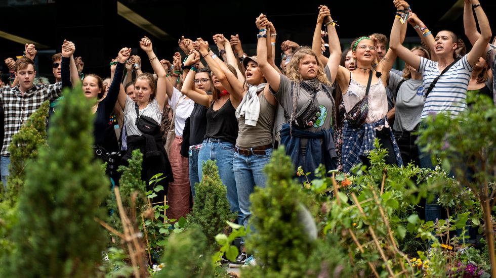 Dortmund: Fridays for Future-Demonstranten haben vor der Zentrale von Innogy SE, einer Tochtergesellschaft des Energieversorgers RWE, Pflanzen aufgestellt und halten sich an den Händen