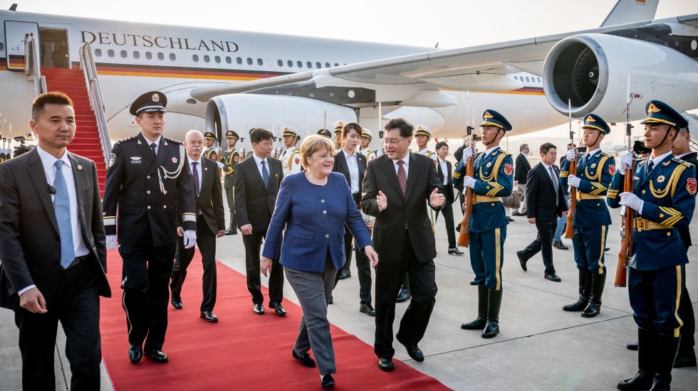 Bundeskanzlerin Angela Merkel steigt nach der Landung am Flughafen Peking in den Airbus A340 ein und wird von Qin Gang begrüßt
