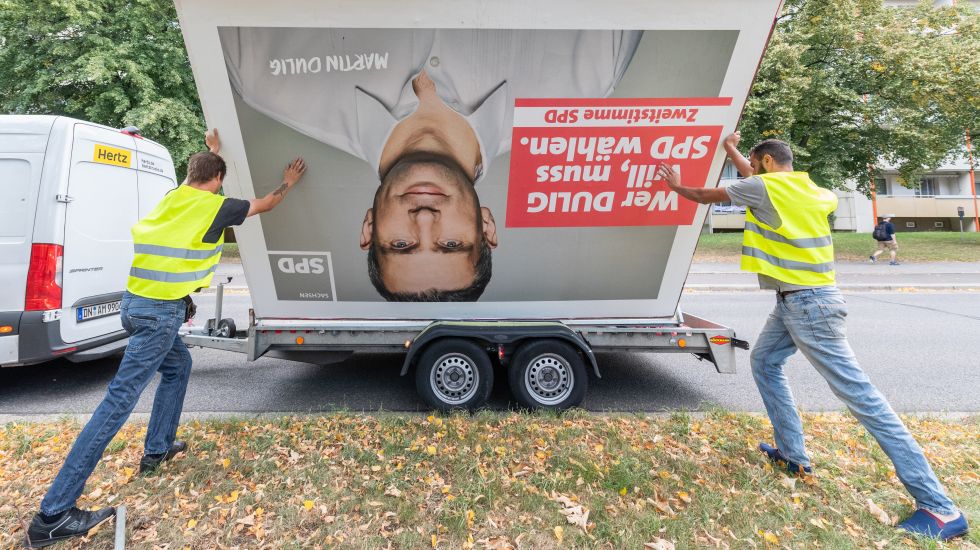 02.09.2019, Sachsen, Dresden: Arbeiter laden nach der Landtagswahl ein SPD Wahlplakat mit dem Foto von Martin Dulig, Spitzenkandidat der SPD, auf einen Anhänger.