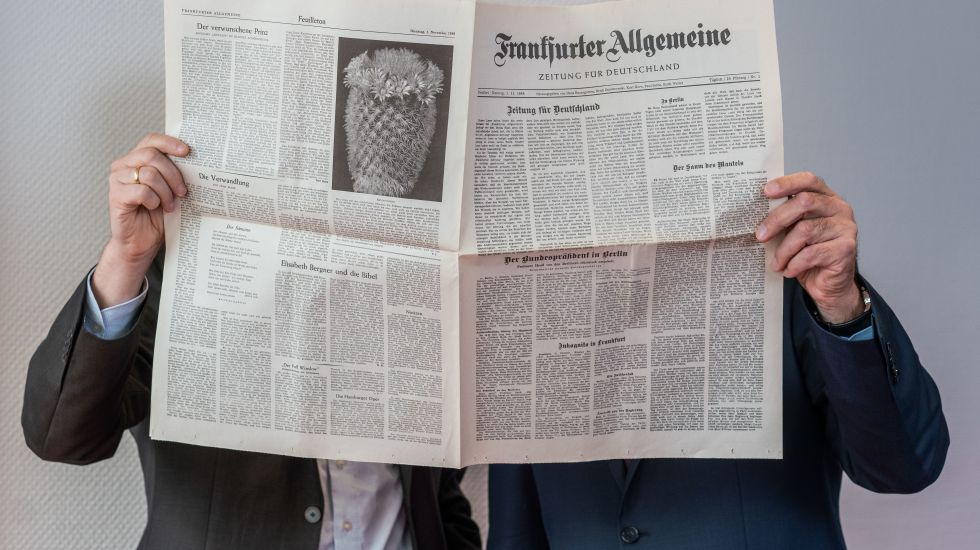 Carsten Knop, Chefredakteur Digitale Produkte (l), und Berthold Kohler, Herausgeber der Frankfurter Allgemeinen Zeitung (FAZ, r), stehen in den Redaktionsräumen hinter einem Exemplar der ersten FAZ-Ausgabe vom 01.11.1949. 