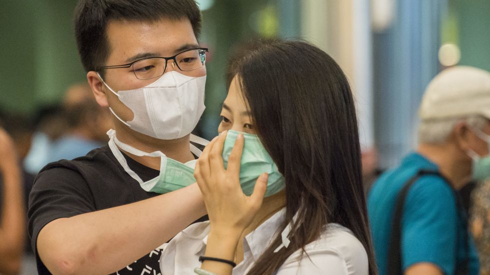 Im Flughafen der indonesischen Insel Batam wappnen sich Reisende mit Mundschutz gegen den Corona-Virus