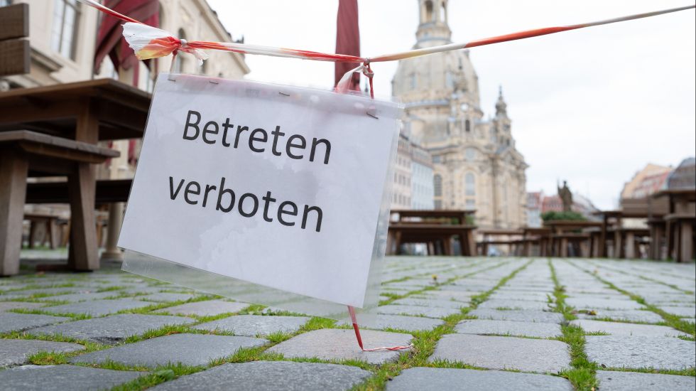Ein Schild mit der Aufschrift „Betreten verboten“ hängt auf dem Dresdner Neumarkt vor der Frauenkirche an einer Terrassenbestuhlung vor einem geschlossenen Restaurant.