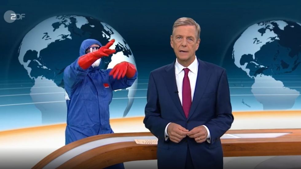 Der Sceenshot einer Szene aus dem ZDF-Nachrichtenmagazin «heute journal» vom 11.09.2020 mit Moderator Claus Kleber zeigt im Hintergrund eine Person in blauer Schutzkleidung und mit roten Gummihandschuhen.