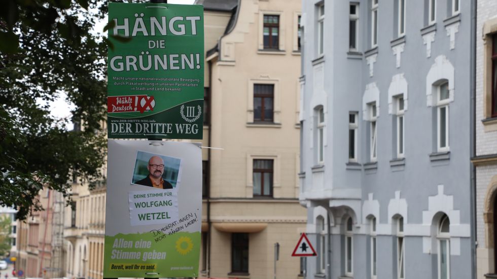 Ein umstrittenes Wahlplakat der Splitterpartei "III Weg" hängt über einem Plakat der grüne