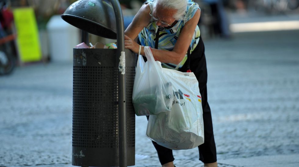 Ältere Frau sammelt Müll