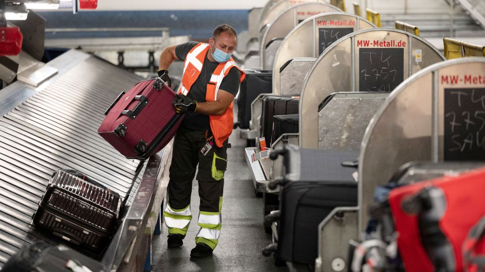 Flughafenmitarbeiter am Gepäckverteiler
