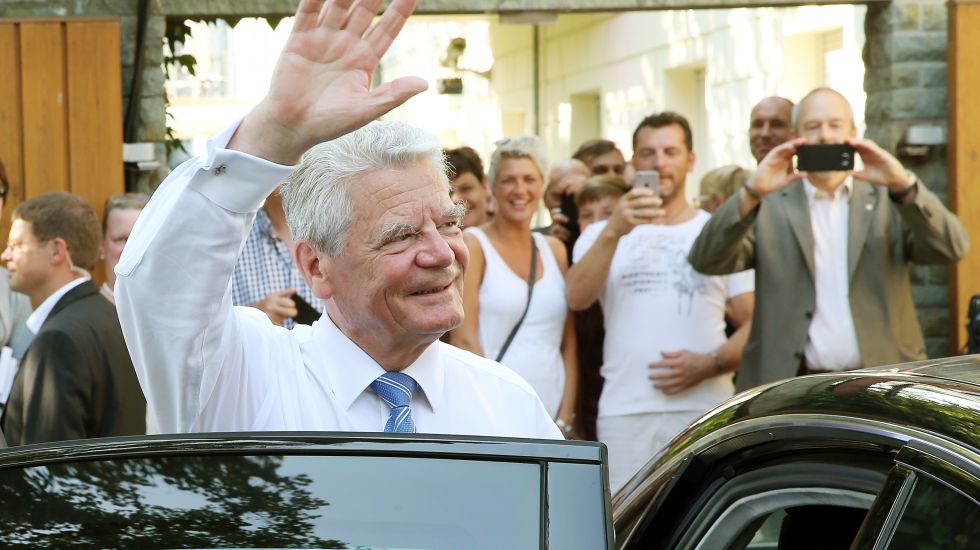 Bundespräsident Joachim Gauck winkt auf dem Gelände von Schloss Bellevue in Berlin den Besuchern zu