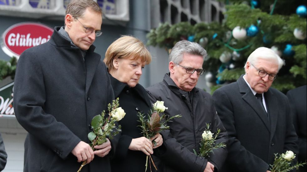 Bundeskanzlerin Angela Merkel (CDU) gedenkt am 20.12.2016 am Ort des Anschlages in Berlin der Opfer zusammen mit Bundesinnenminister Thomas de Maizière (CDU) Außenminister Frank-Walter Steinmeier (SPD (rechts)) und mit dem Regierenden Bürgermeister von Berlin, Michael Müller (SPD, links).
