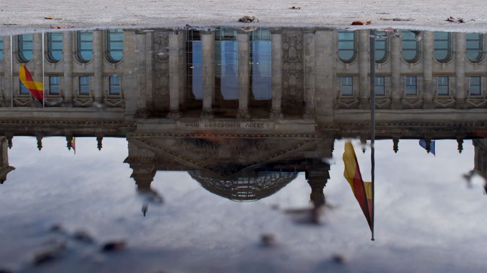 Das Bundestagsgebäude spiegelt sich in einer Pfütze