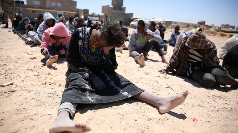 Erschöpfte Flüchtlinge an einem libyschen Strand