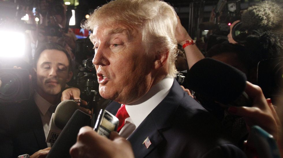 Donald Trump umzingelt von Mikrofonen und Kameras