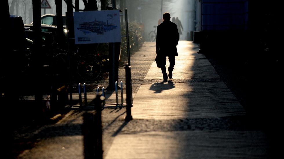 Ein Mann läuft bei Sonnenaufgang durch die Straßen Berlins
