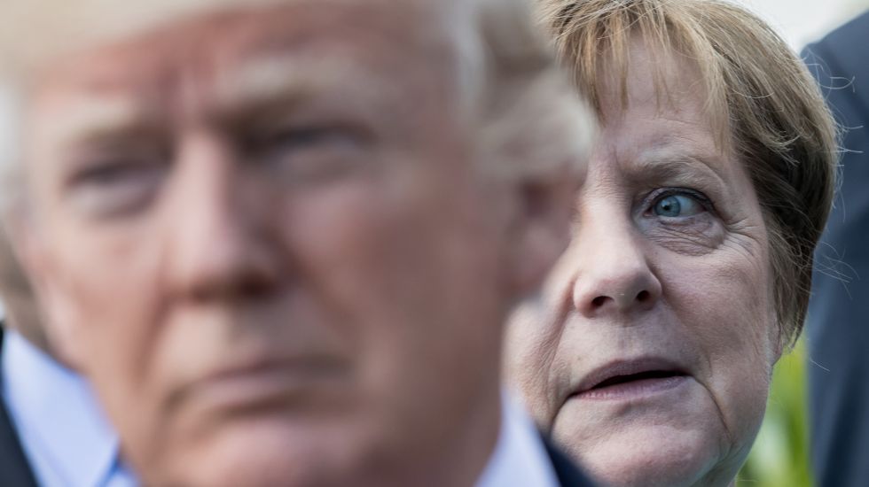 US-Präsident Donald Trump steht vor Bundeskanzlerin Angela Merkel (CDU) am 27.05.2017 beim Familienfoto der G7 Staaten mit den Outreach-Partnern in Taormina auf Sizilien